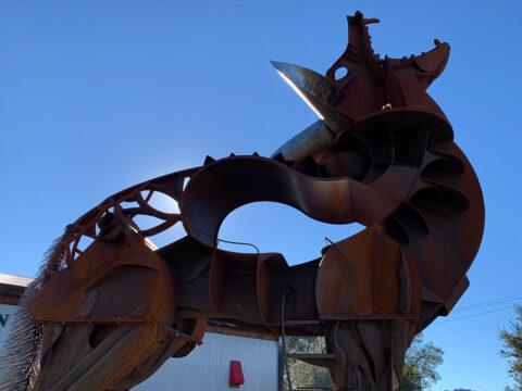 Large rusted metal horse sculpture outdoors