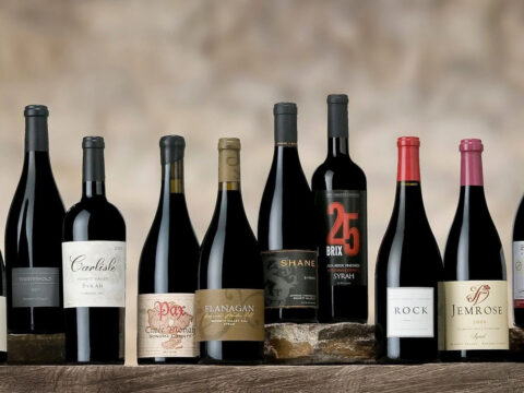 Assorted Syrah wine bottles on wooden table