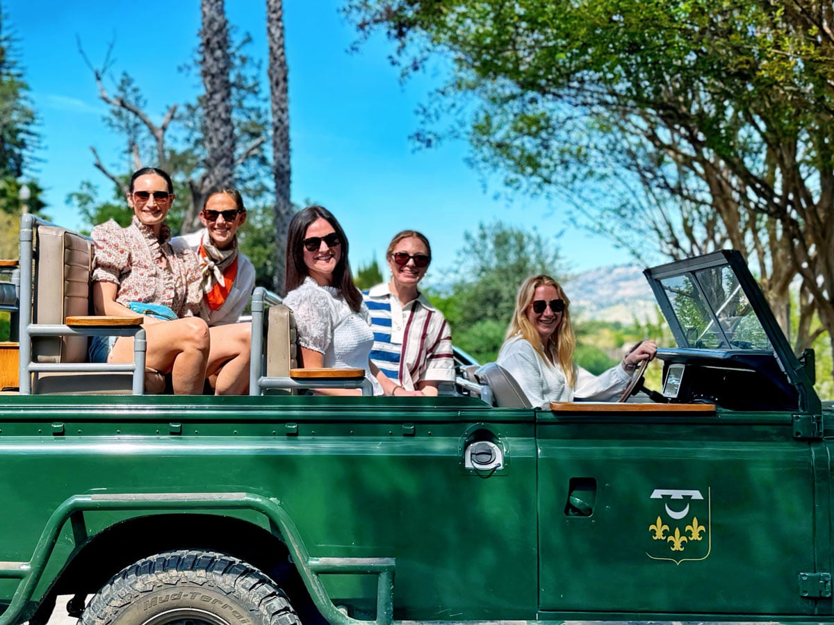 Five women in green open-top safari vehicle