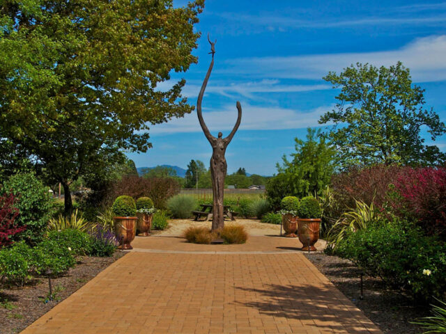 Garden pathway leading to tall abstract sculpture