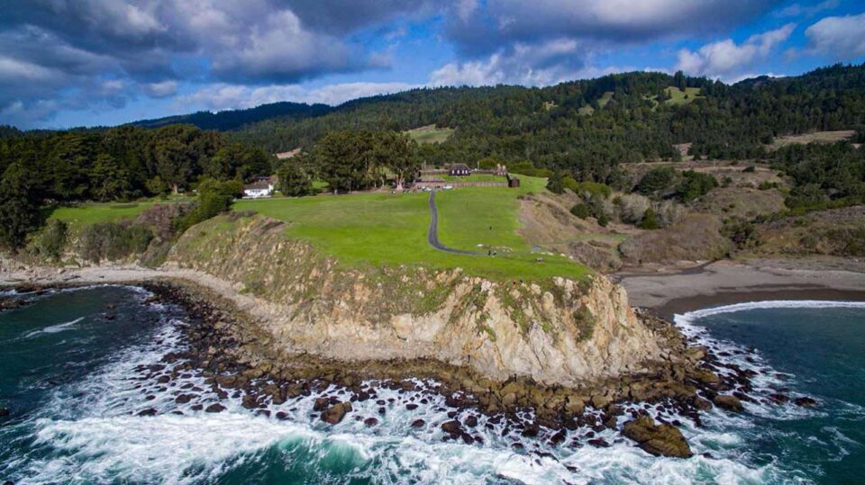 Aerial view of grassy coastal cliff and waves
