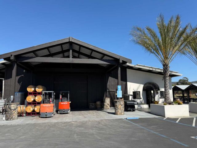 Winery warehouse with barrels and forklifts outside