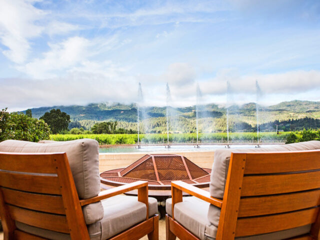 Wooden chairs overlooking vineyard fountain and hills